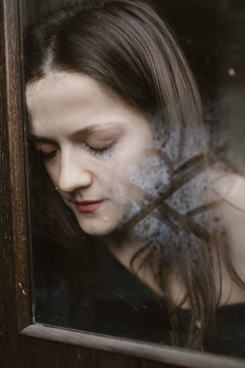 Free Woman with eyes closed, resting peacefully behind a glass window. Stock Photo
