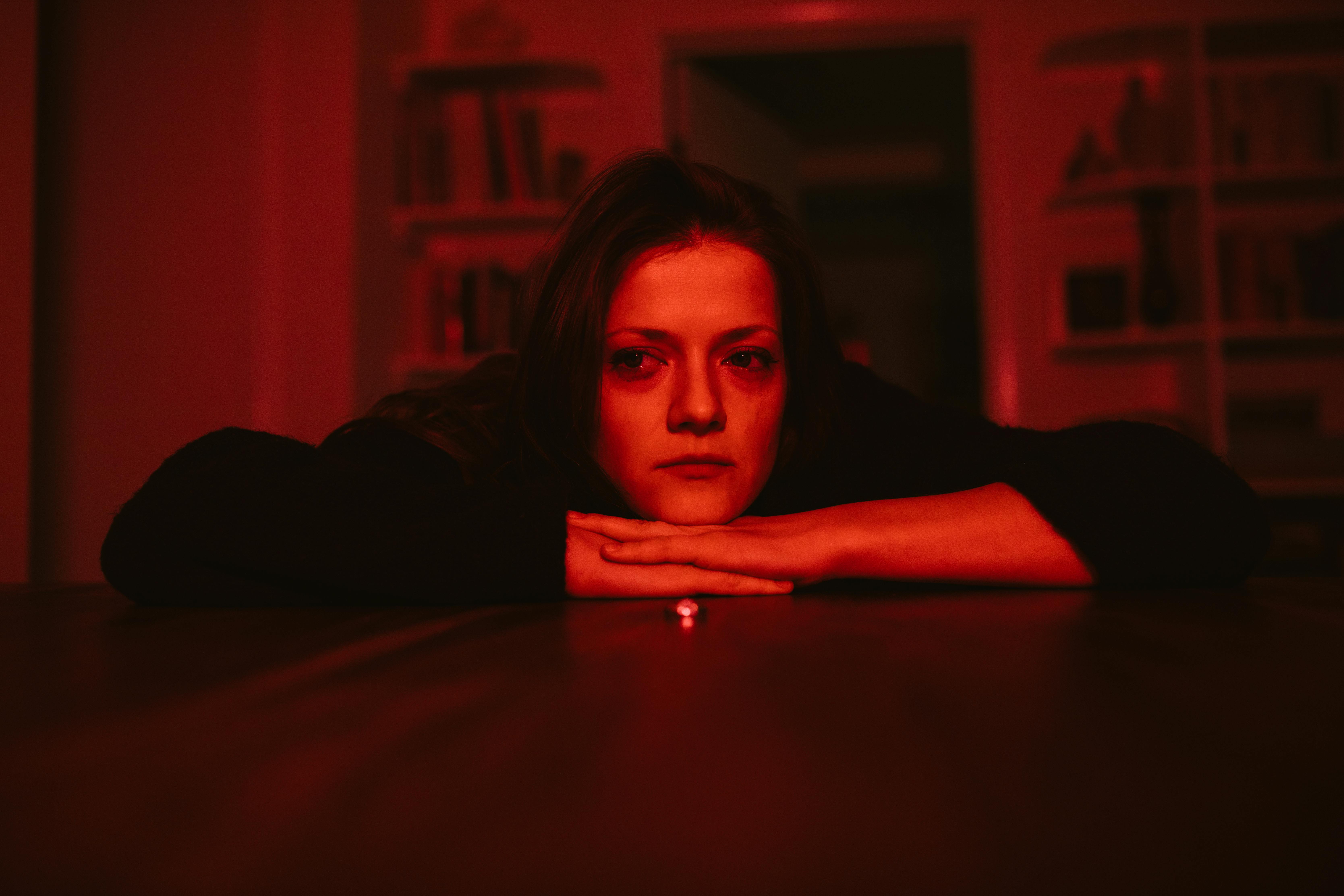 young woman in black long sleeve shirt looking pensive