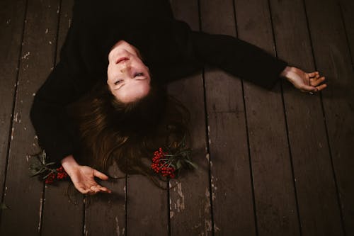 A Lonely Woman Lying Down on the Wooden Floor
