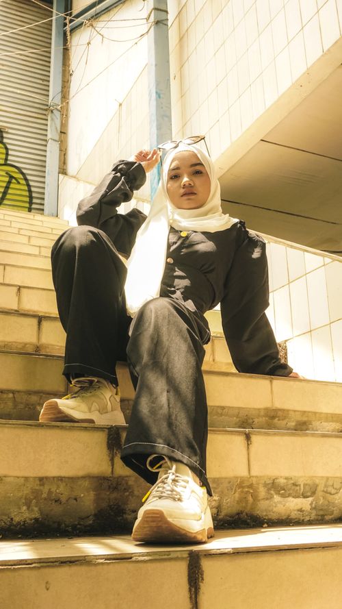 Free Fashionable woman in hijab with sunglasses posing on city stairs in Cirebon, Indonesia. Stock Photo