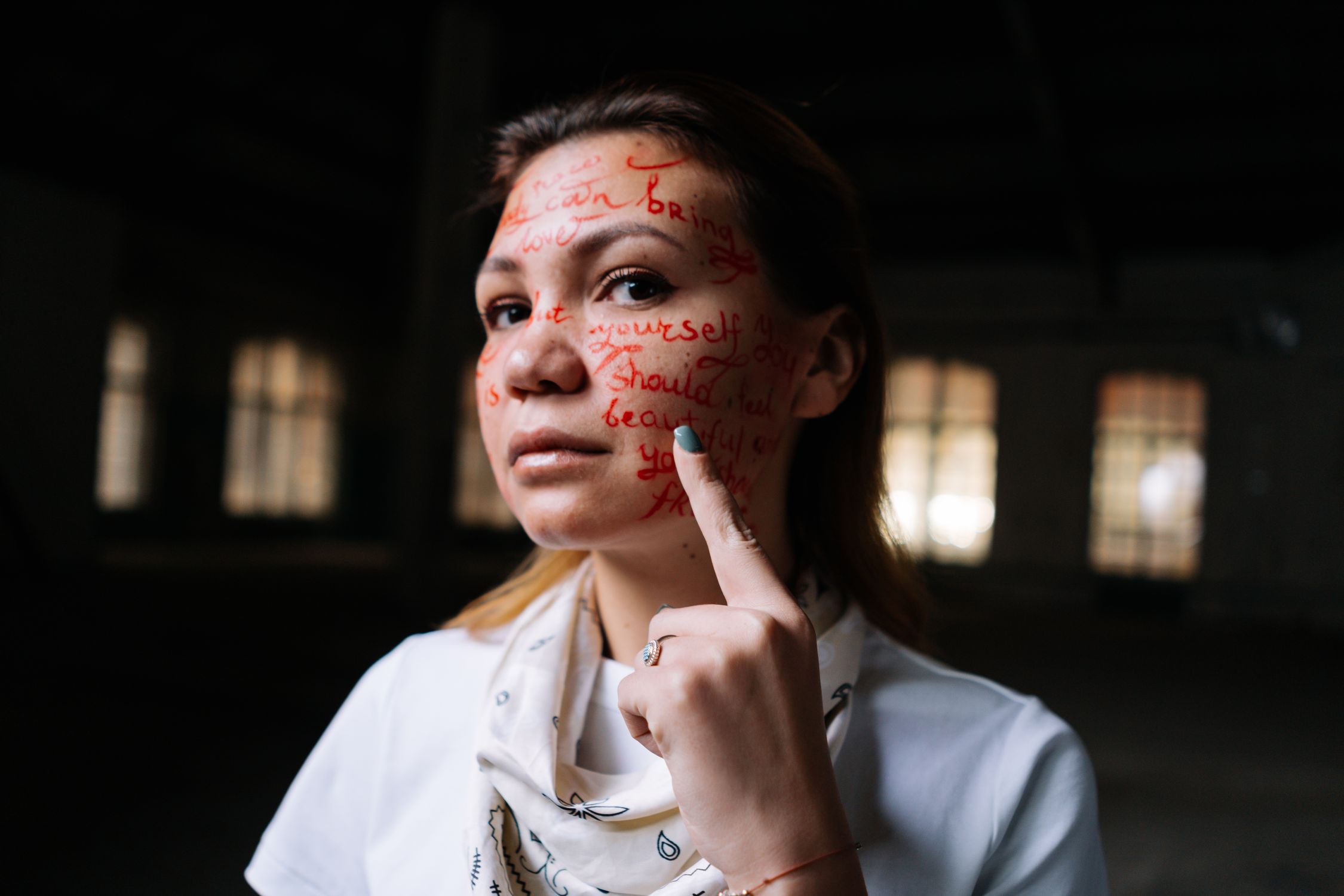 Mulher com palavras escritas no rosto em uma expressão artística de identidade