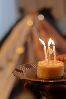 Vertical shot of a birthday cake with three lit candles, symbolizing a festive celebration.