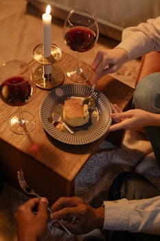 Intimate setting with cake, wine, and candlelight, perfect for a cozy evening celebration.
