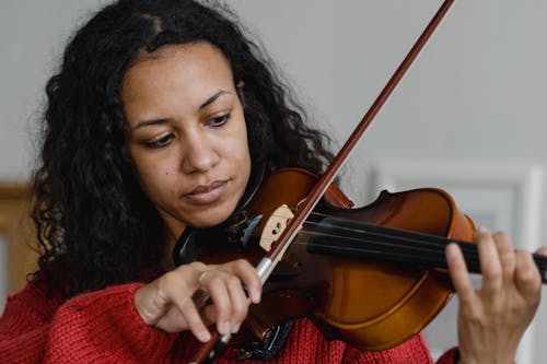 Close-Up Photograph of a Woman Playing the Violin