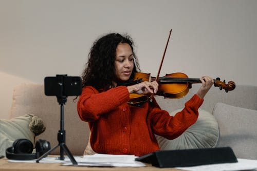 A Person Recording Herself While Playing a Violin