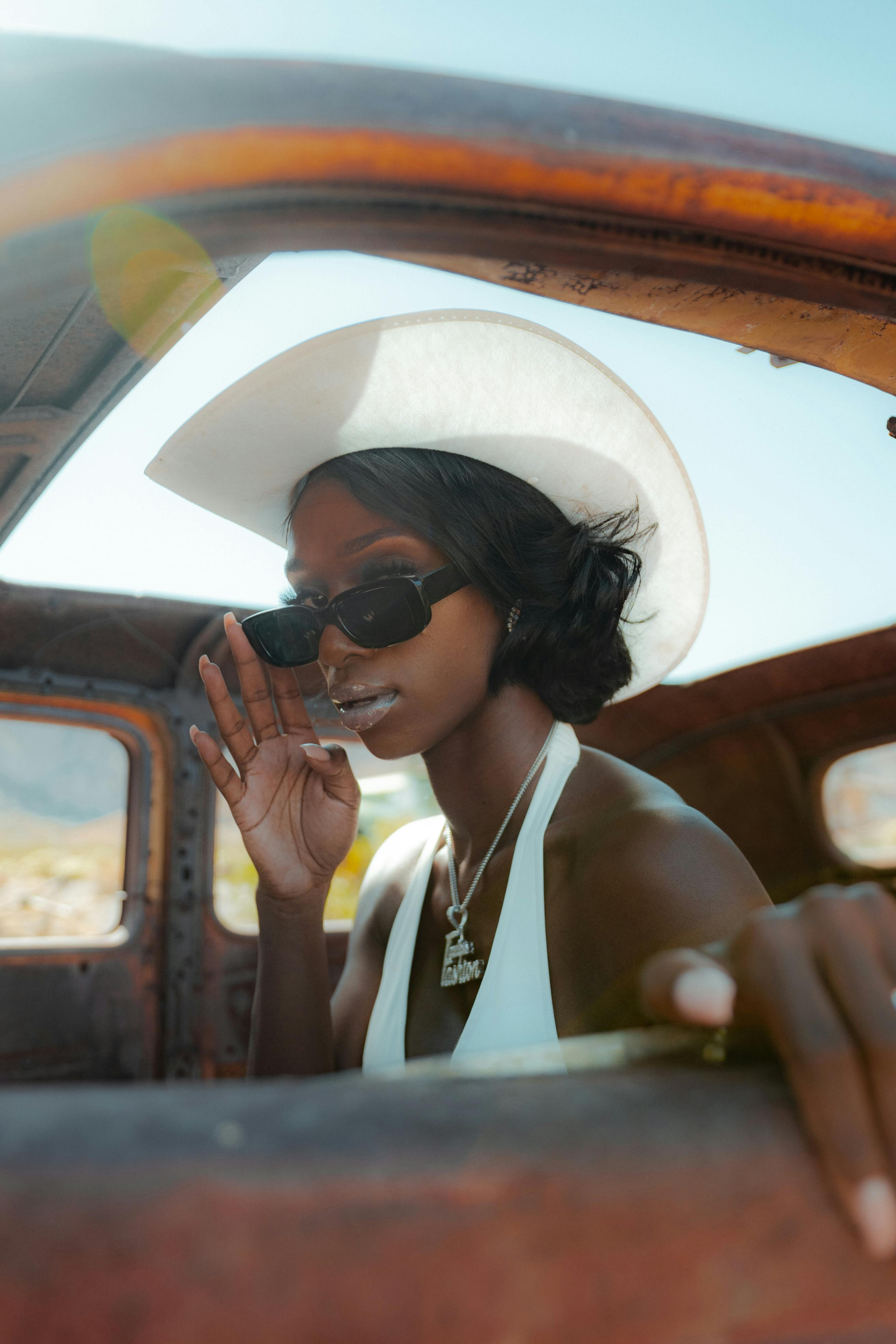 confident trendy black woman in retro car