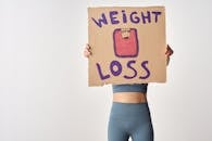 Person Holding a Cardboard with Weight Loss Message