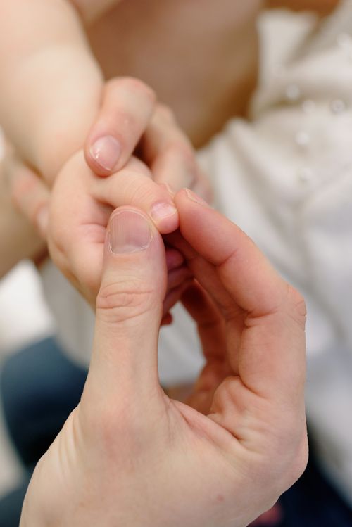 Free Tender close-up of adult holding a baby's hand, symbolizing care and love. Stock Photo