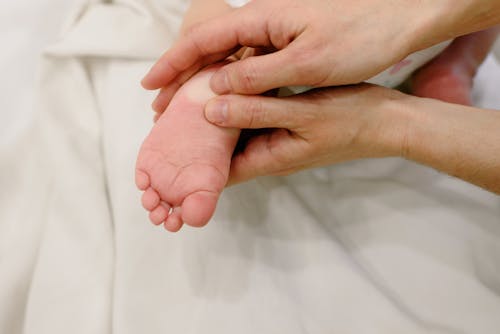 Free Person Massaging a Baby's Foot Stock Photo