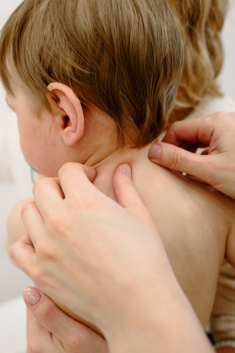 Person Massaging Baby's Back