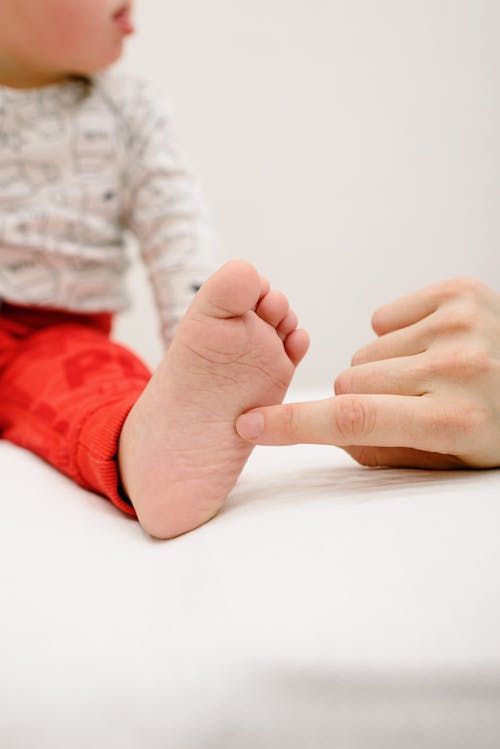 Free Person Touching a Baby's Foot Stock Photo