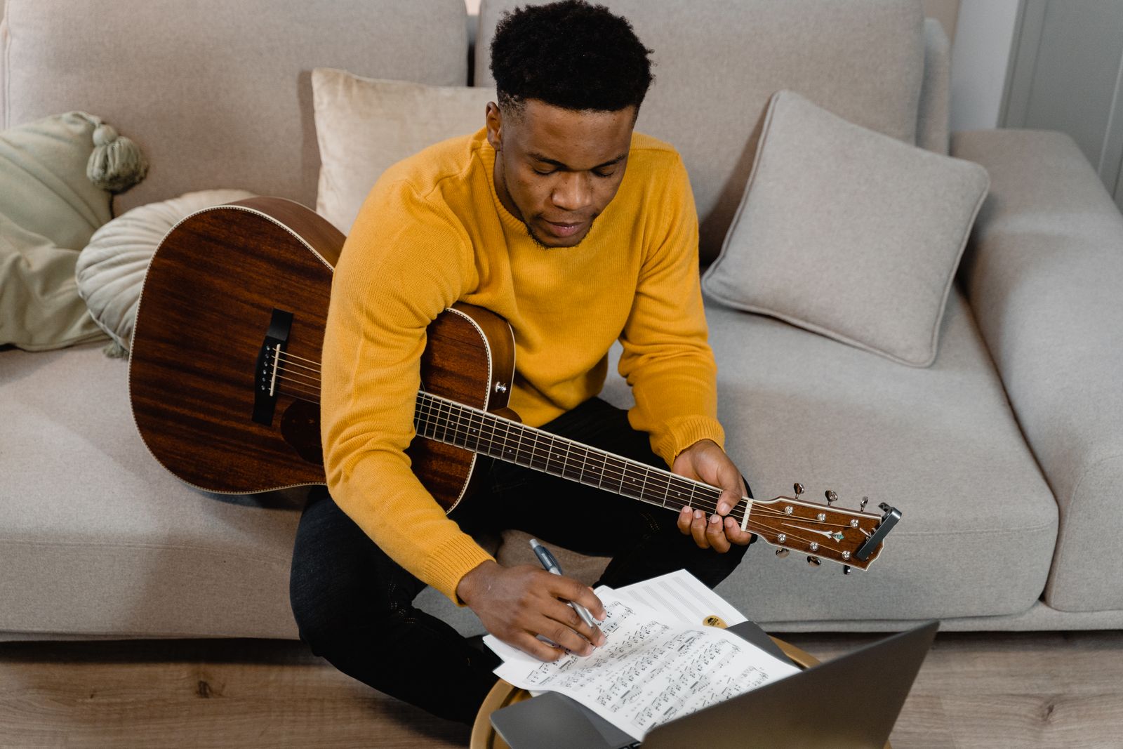 Songwriter working on music with an acoustic guitar