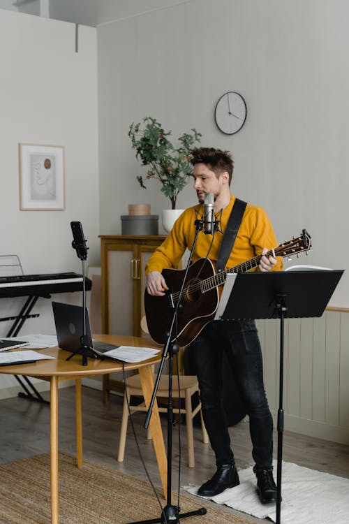 Man Playing Guitar While Singing