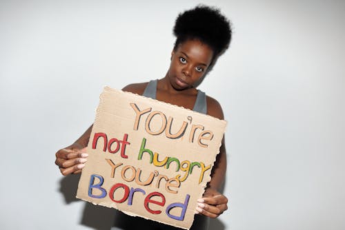 Woman Holding Cardboard with Food Related Slogan