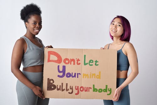 Free Women Wearing Activewear Holding a Cardboard with Message  Stock Photo