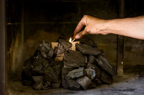 Hand Starting Fire in Fireplace