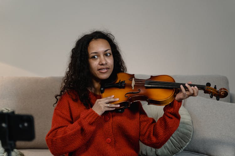 Curly Haired Woman In Knitted Sweater Playing Violin 