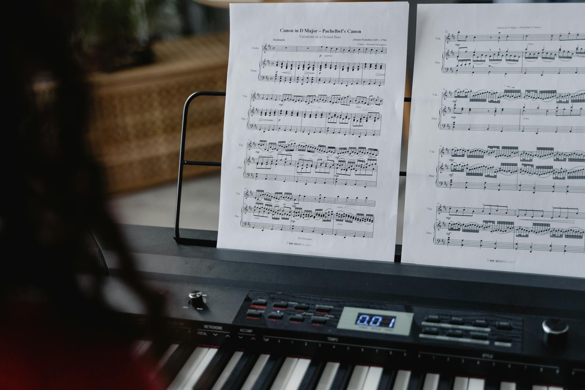 Close-up of a digital piano with sheet music on a stand, focused on keys and composition.