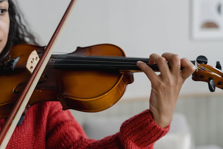 Person In Red Knitted Sweater Playing Violin 