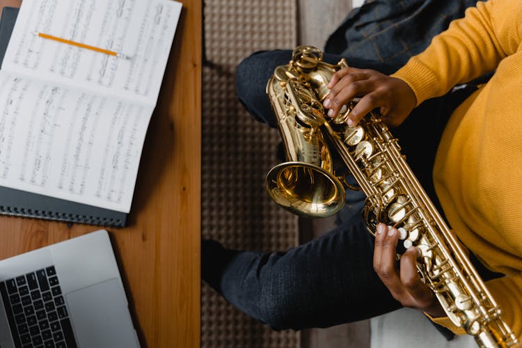 Top View Of Person In Yellow Sweater Playing  Saxophone