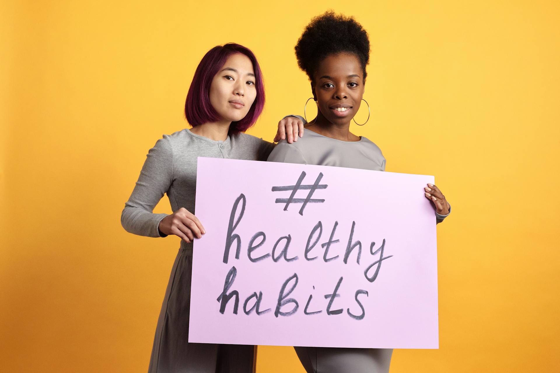 Women Standing and Holding a Poster