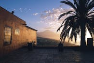 日落景观令人惊叹，棕榈树的轮廓映衬在山景之中