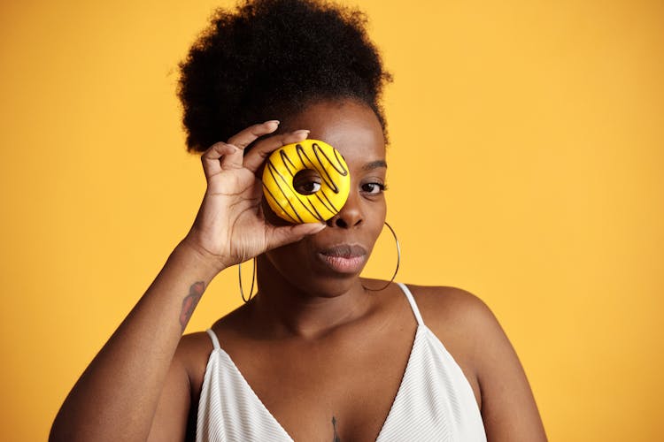 Woman Posing Holding A Yellow Donut 