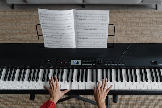 Top view of hands playing piano with sheet music on display, perfect for music learning themes.