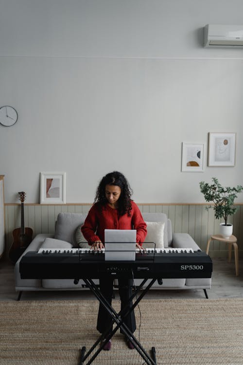 Woman in the Living Room Playing Digital Piano