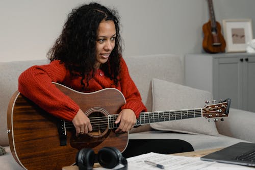 Free Woman Holding Her Acoustic Guitar on Her Lap  Stock Photo