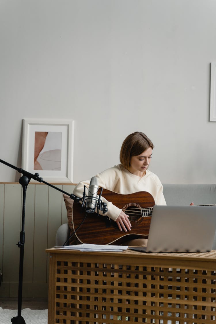 A Woman Learning To Play Guitar Online