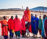 Photo of Group of Men Wearing Assorted Scarves Holding Sticks