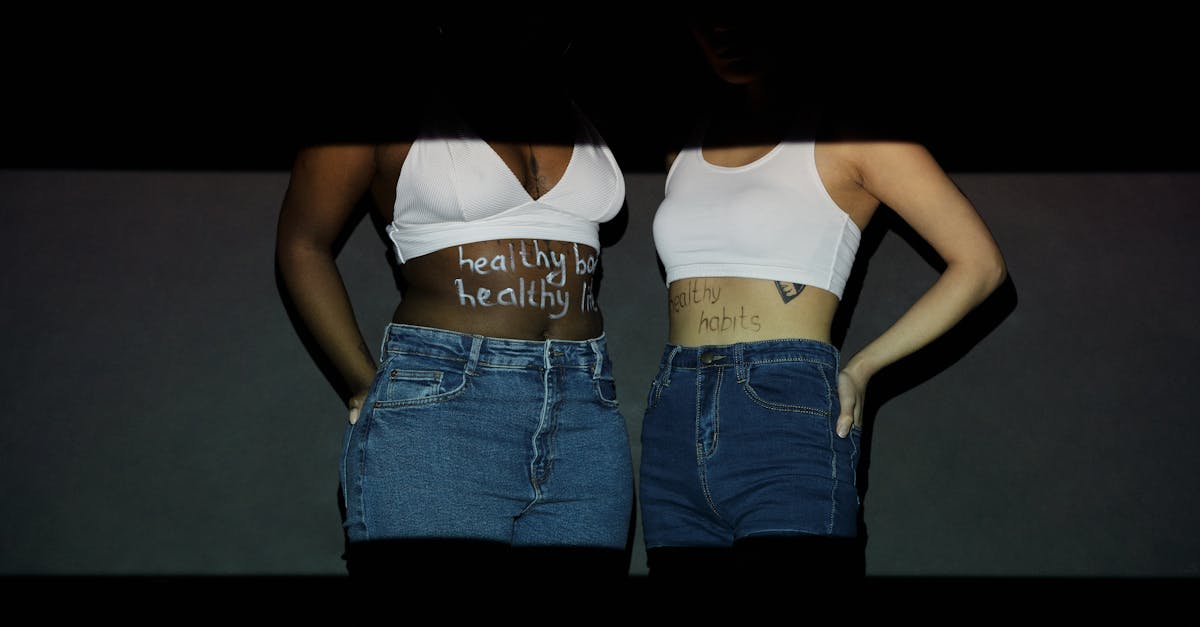 Two women promote healthy habits with inspiring text on their bodies.