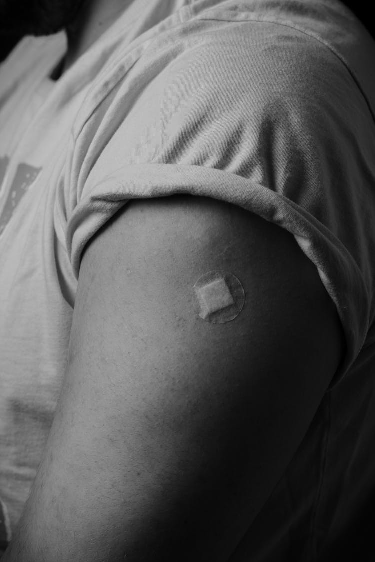 A Person With A Band Aid On The Arm