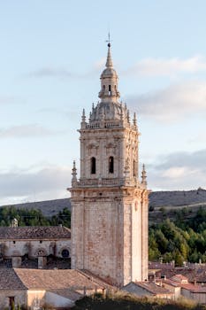 Historic Gothic tower in Ciudad de Osma, Spain against blue sky.