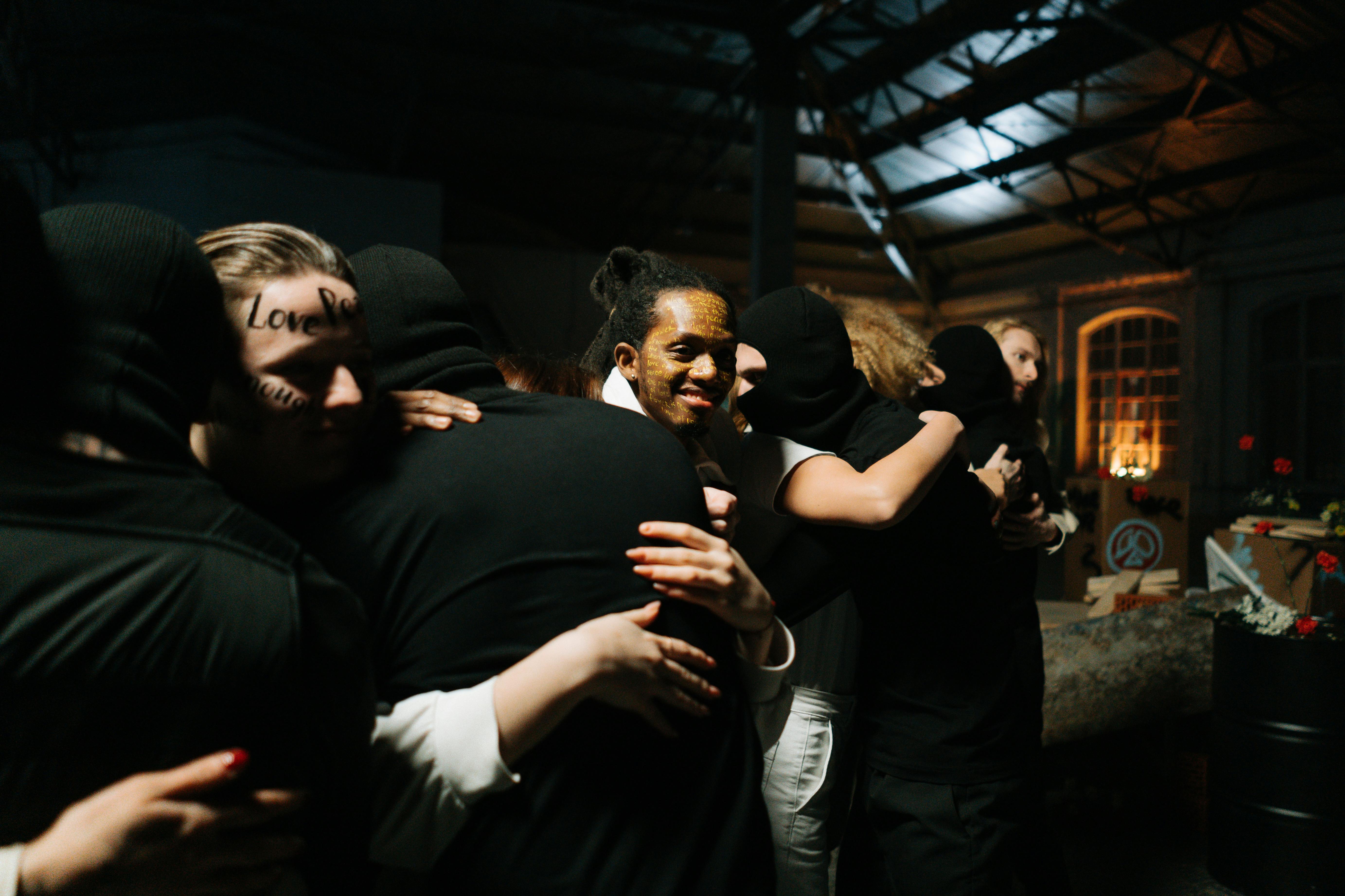 Diverse group of people in a warm, connected embrace - Polyamory and attachment