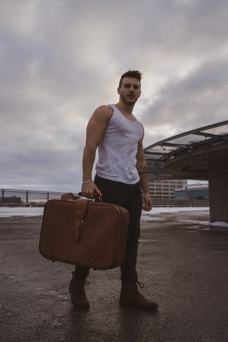 A Man Carrying A Suitcase