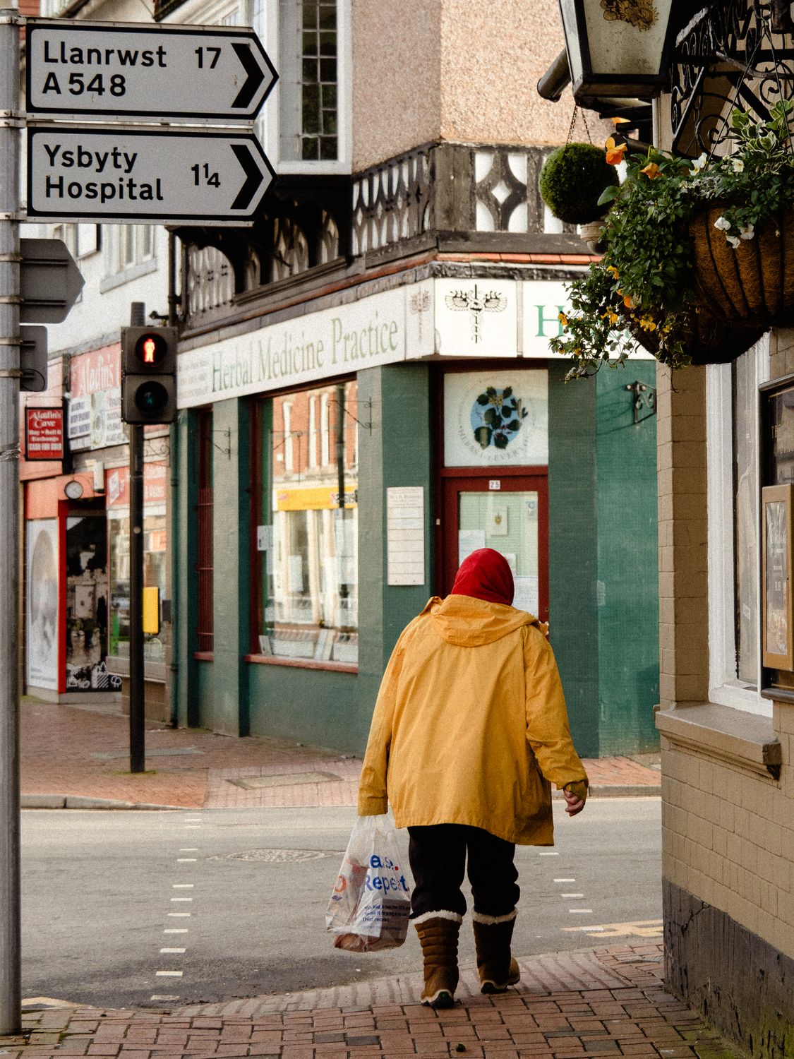 A Person Wearing a Yellow Jacket Walking on a Sidewalk · Free Stock Photo