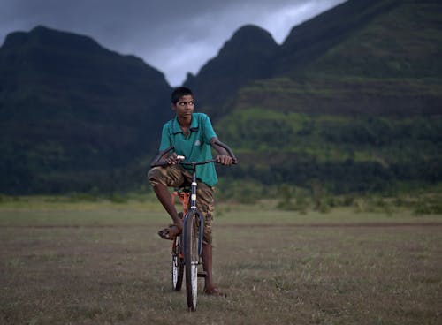 A Boy Riding a Bicycle on a Field