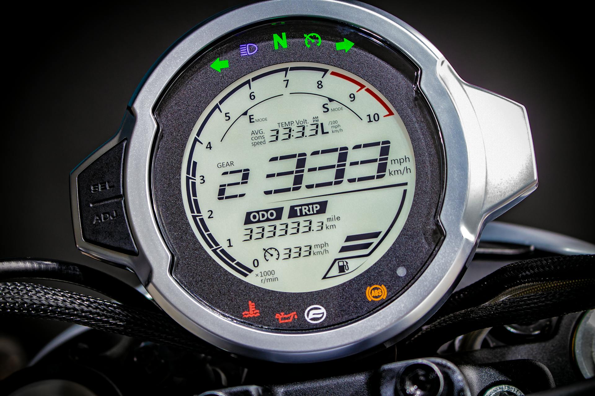 Close-up of a digital motorcycle speedometer displaying gauges and measurements.