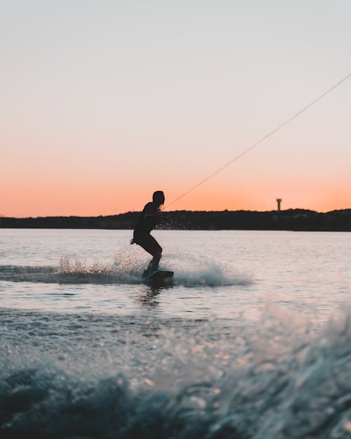 Silhouette of Person on Wakeboard During Sunset 