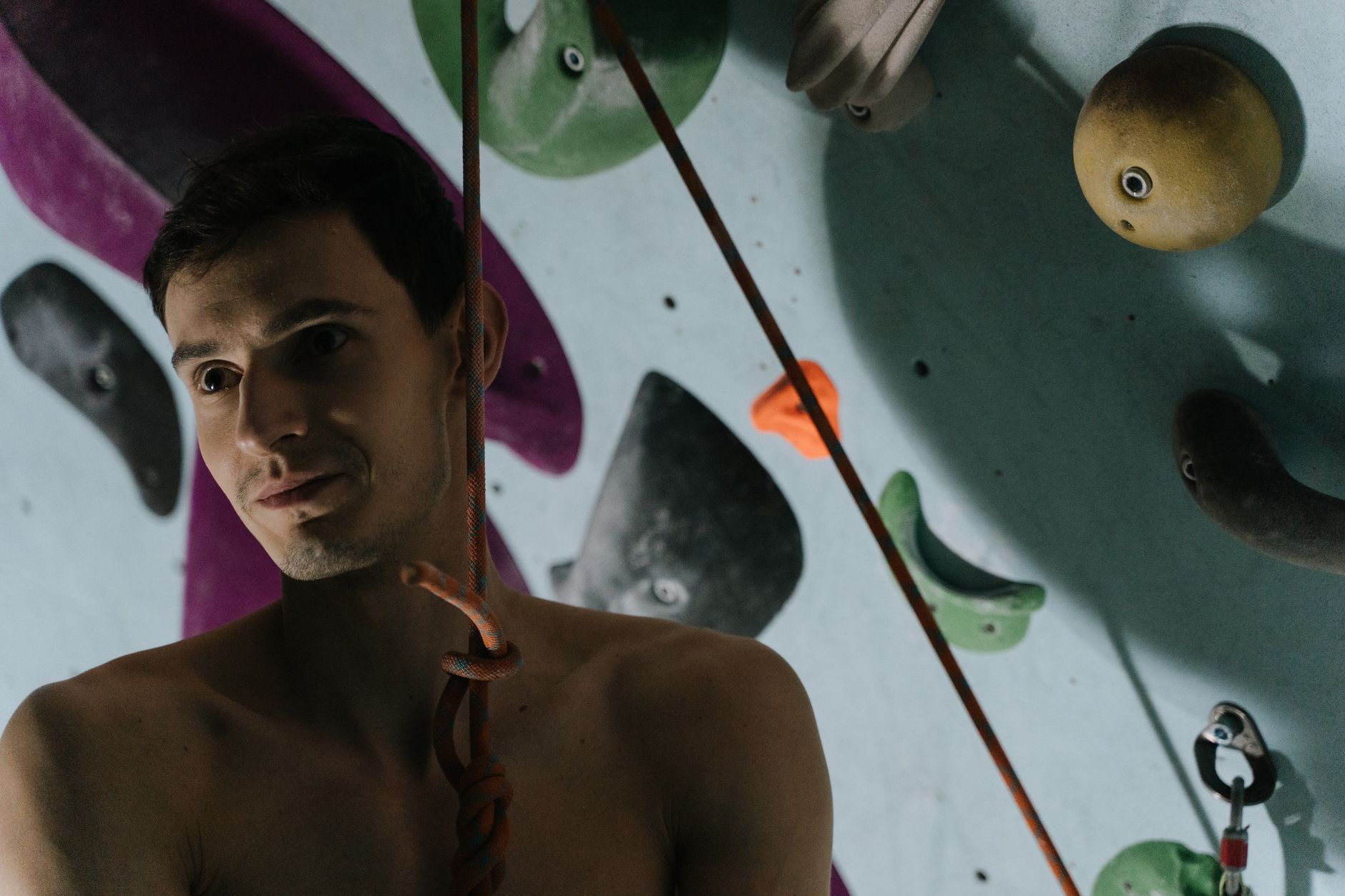 Focused man climbing an indoor wall, showcasing strength and flexibility.