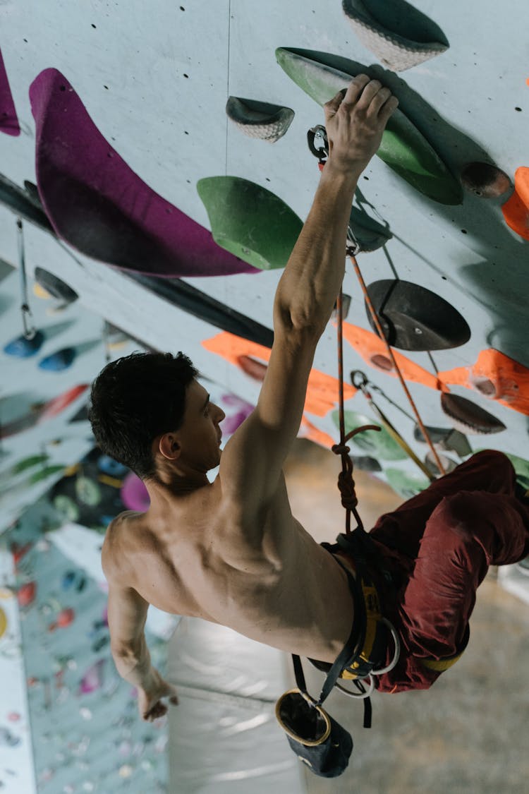 Athletic Shirtless Man Doing Indoor Rock Climbing