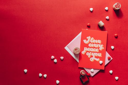 Greeting Card and Heart Shape Materials on Red Surface