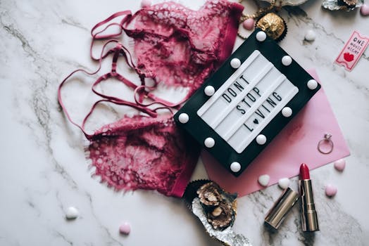 A romantic flat lay featuring red lingerie, love message, and lipstick.