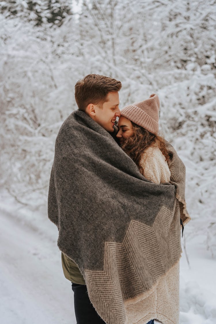 Couple Cuddling With A Blanket 