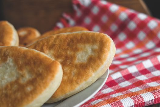 Close-up of freshly baked bread on a ceramic plate with checkered tablecloth background.