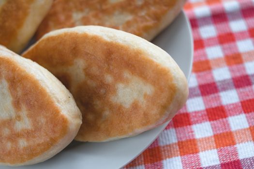 Close-up of freshly baked breads on a ceramic plate with a vibrant checkered tablecloth background.