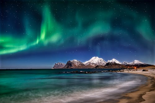 Mountain and Beach Under Aurora Borealis