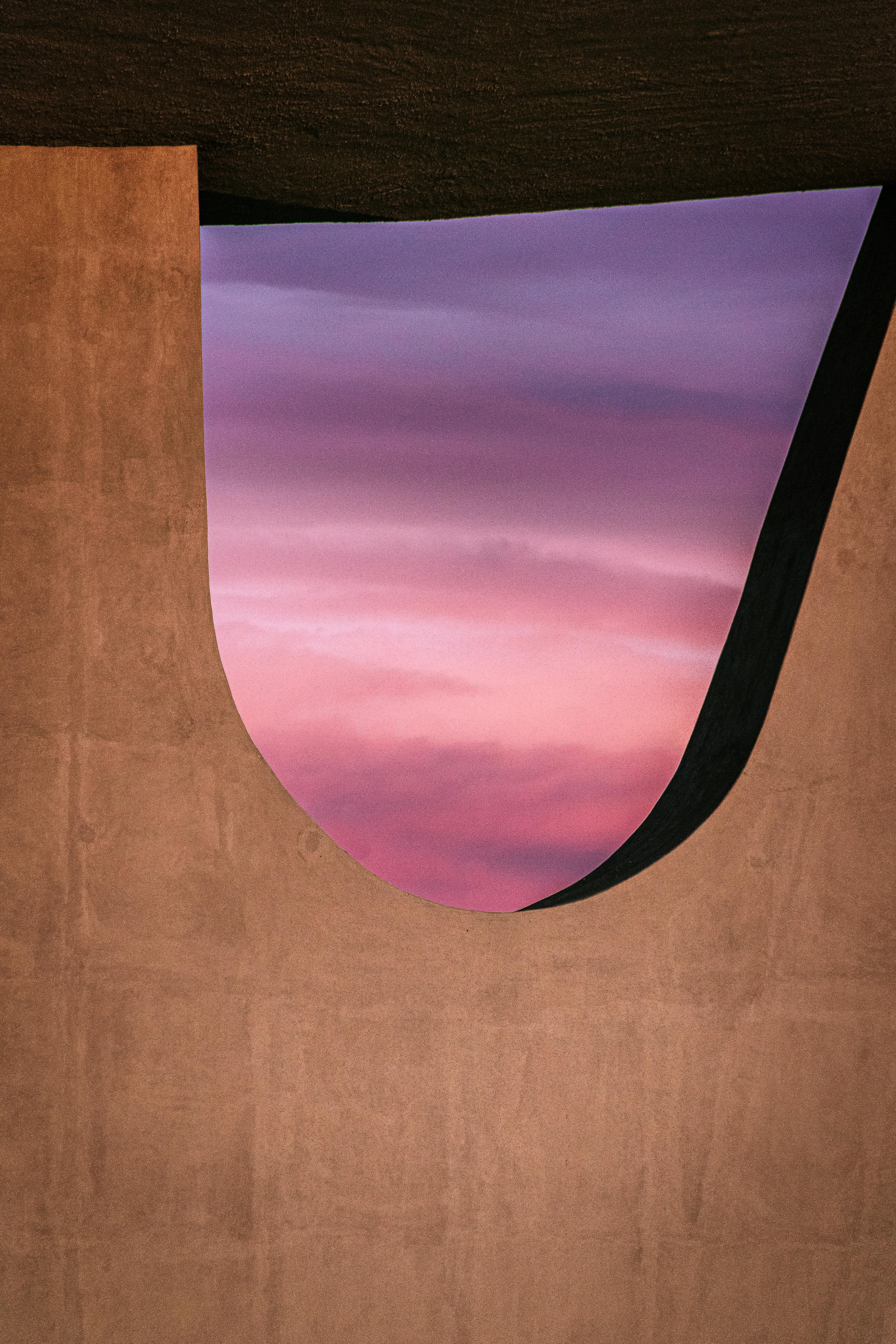 Vibrant purple and pink sunset framed by unique Brazilian architecture.